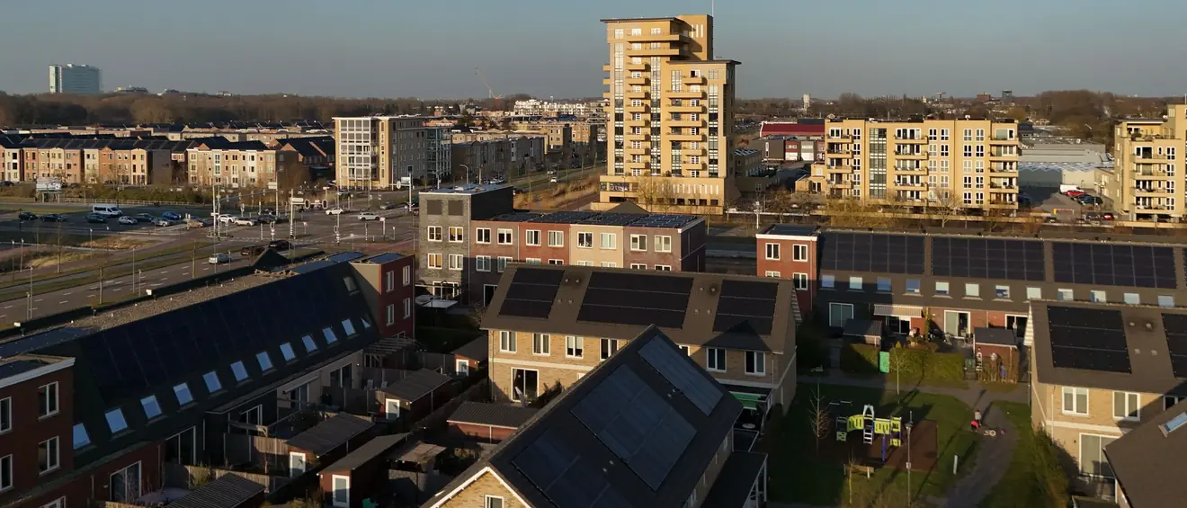Nederlandse nieuwbouwwijk van bovenaf, met zonnepanelen op de daken